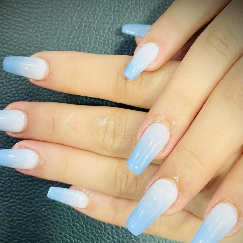 Ongles longs avec vernis semi-permanent en dégradé blanc et bleu ciel